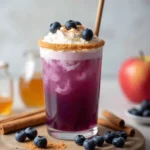 Blueberry Pie Mocktail with graham cracker rim, whipped cream, fresh blueberries, and a sprinkle of cinnamon.